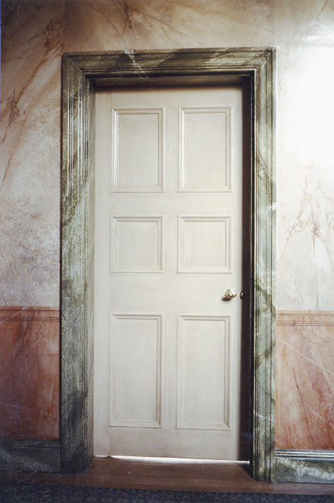 Faux marbre sur un pan de mur entourant une porte