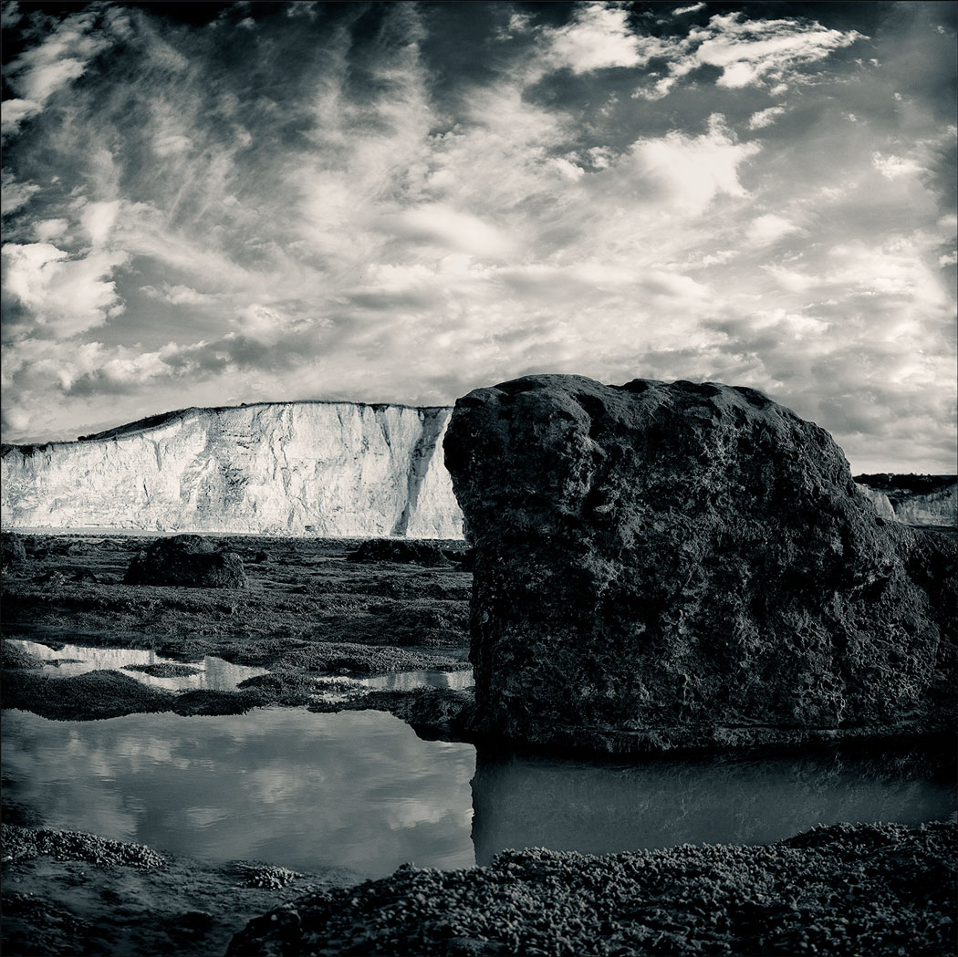 Photographie numérique avec un gros rocher en premier plan et la falaise en arrière plan