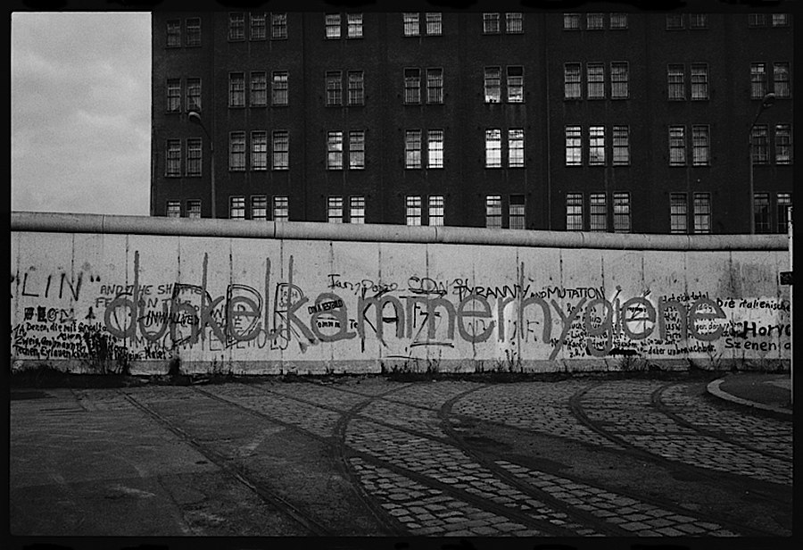 Photographie noir et blanc d'un bout du rideau de fer avec graffitis